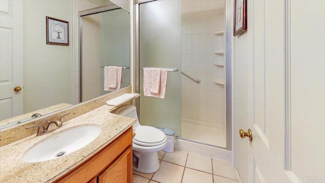 bathroom with tile patterned floors, vanity, toilet, and a shower stall