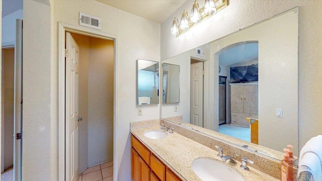 bathroom with tile patterned floors, double vanity, visible vents, and a sink