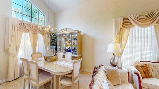 dining room featuring light tile patterned floors, baseboards, and an inviting chandelier