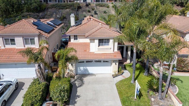 mediterranean / spanish-style house with a front lawn, stucco siding, an attached garage, a tile roof, and driveway