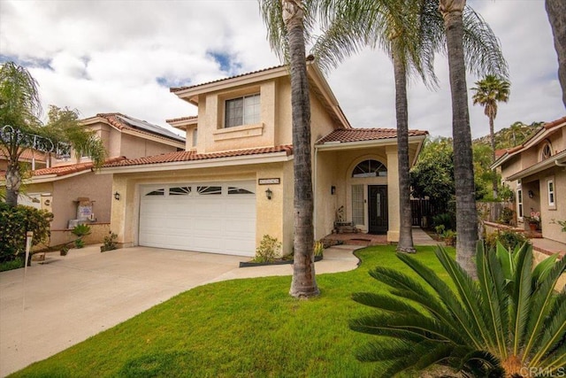 mediterranean / spanish home featuring stucco siding, a tile roof, a front yard, and concrete driveway