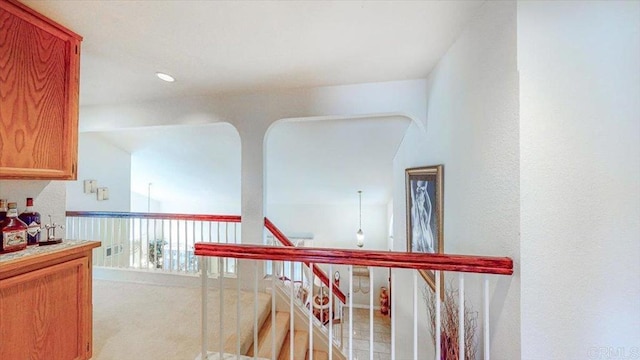 hall featuring carpet floors and an upstairs landing