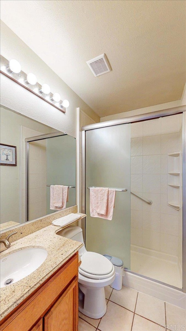 full bath featuring toilet, visible vents, tile patterned flooring, a shower stall, and vanity