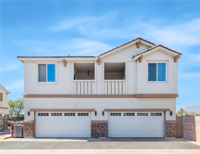 view of front facade featuring stucco siding, stone siding, and an attached garage