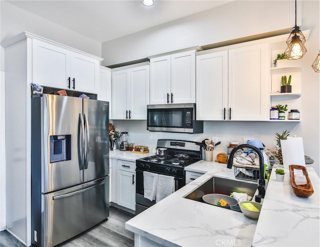 kitchen with a sink, open shelves, white cabinetry, stainless steel appliances, and light stone countertops