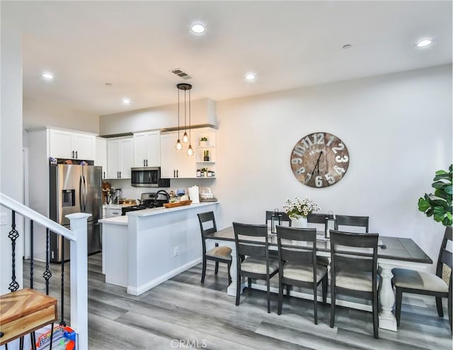 dining area featuring recessed lighting, light wood-style flooring, stairs, and visible vents