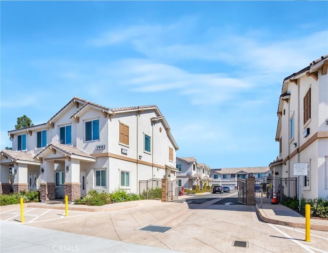 view of street featuring a gated entry, a residential view, a gate, and sidewalks