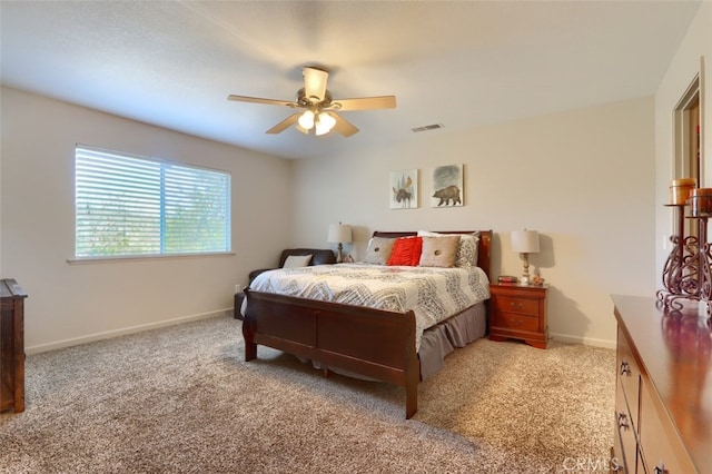 bedroom featuring visible vents, baseboards, light colored carpet, and a ceiling fan