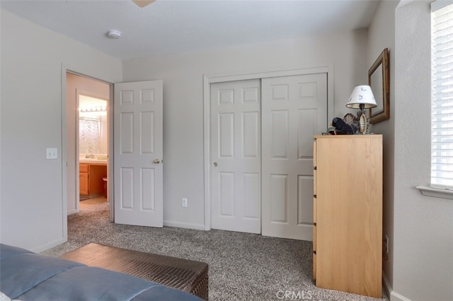 carpeted bedroom with a closet and baseboards