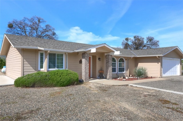 ranch-style house with a garage, driveway, and a shingled roof