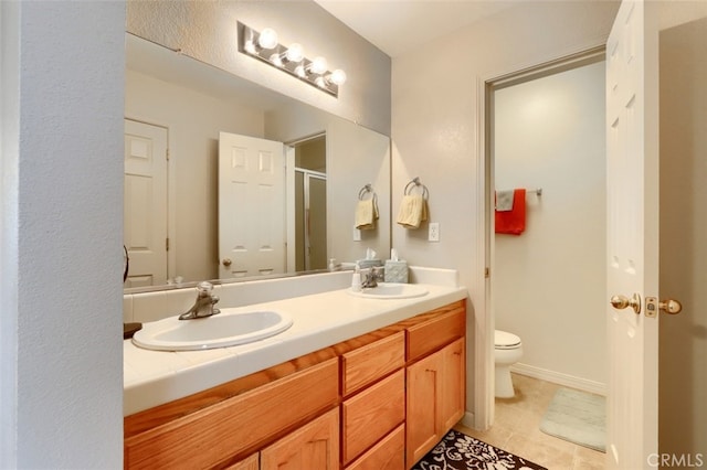 bathroom featuring double vanity, toilet, a stall shower, and a sink