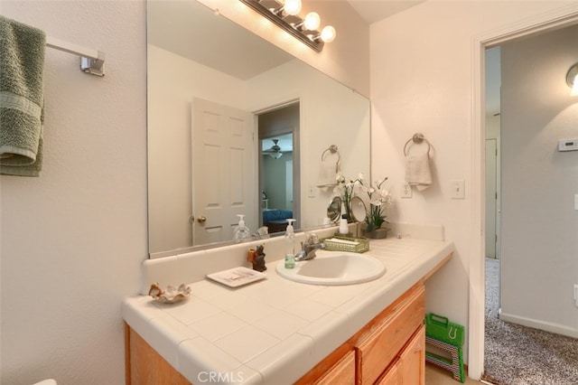 ensuite bathroom with vanity, ensuite bath, and baseboards