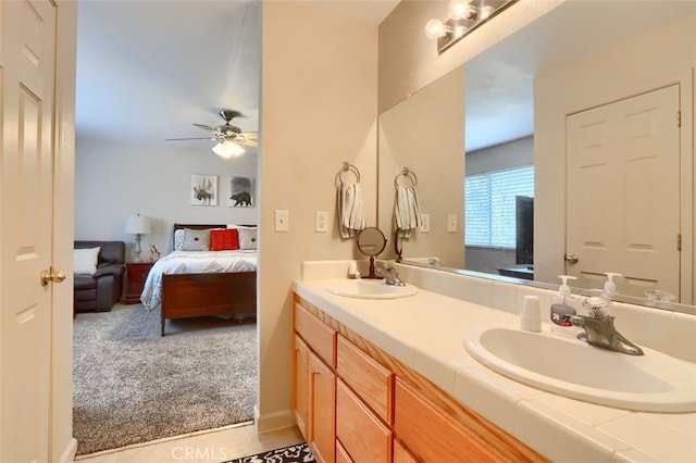 bathroom with double vanity, connected bathroom, a ceiling fan, and a sink