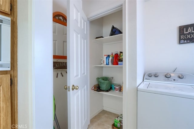 washroom featuring light tile patterned floors, laundry area, washer / dryer, and baseboards