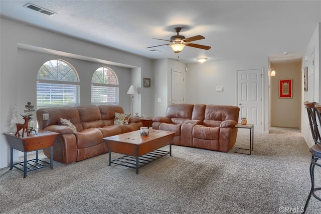 carpeted living area featuring visible vents and ceiling fan