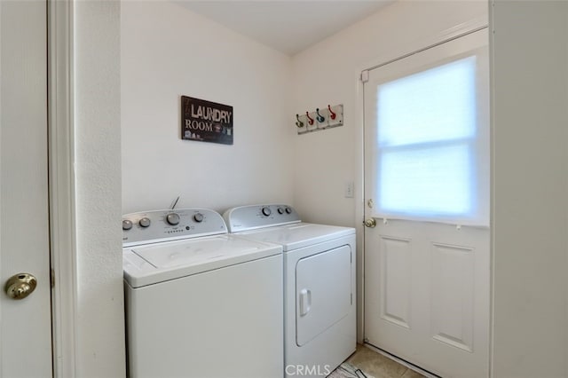 laundry area with separate washer and dryer, light tile patterned flooring, and laundry area