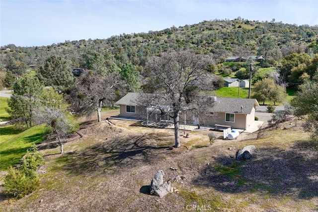 drone / aerial view featuring a wooded view