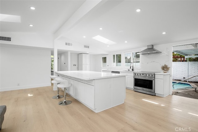 kitchen featuring visible vents, a healthy amount of sunlight, appliances with stainless steel finishes, and wall chimney exhaust hood