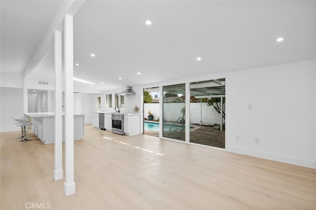 unfurnished living room with light wood finished floors, visible vents, recessed lighting, and baseboards