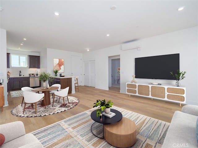 living room featuring recessed lighting, a wall mounted AC, and light wood-style floors