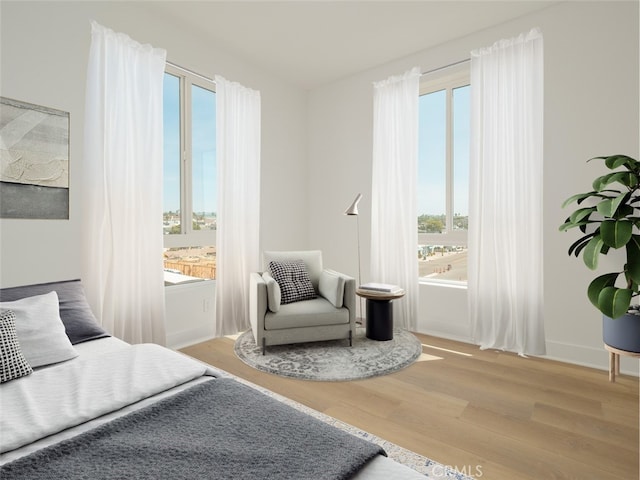 bedroom featuring baseboards, wood finished floors, and multiple windows