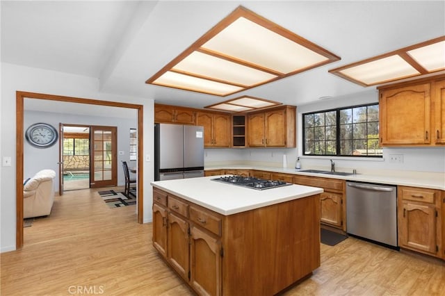 kitchen featuring brown cabinetry, light wood finished floors, appliances with stainless steel finishes, and light countertops