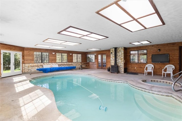 view of pool with a covered pool, a skylight, and french doors