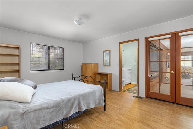 bedroom featuring light wood-style flooring, multiple windows, french doors, and visible vents