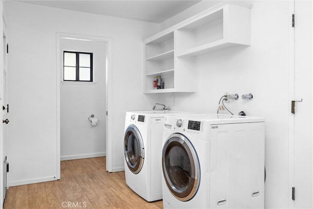 laundry area featuring laundry area, light wood-style flooring, separate washer and dryer, and baseboards