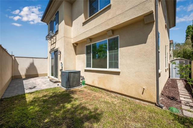 3242 Harmona Pl, Los Alamitos, CA 90720 - view of home's exterior featuring a lawn, central AC, fence, a patio, and stucco siding