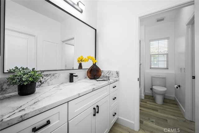 3242 Harmona Pl, Los Alamitos, CA 90720 - bathroom with visible vents, wood finished floors, vanity, baseboards, and toilet