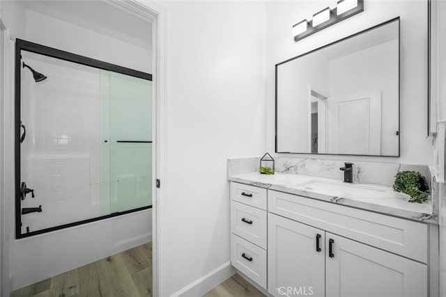 3242 Harmona Pl, Los Alamitos, CA 90720 - bathroom with vanity, baseboards, bath / shower combo with glass door, and wood finished floors