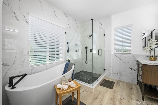 3242 Harmona Pl, Los Alamitos, CA 90720 - full bath with a freestanding tub, tile walls, wood finished floors, vanity, and a marble finish shower