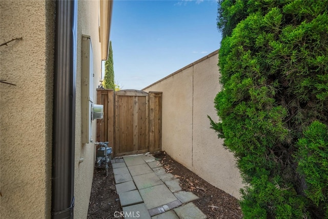 3242 Harmona Pl, Los Alamitos, CA 90720 - view of side of home with a gate, stucco siding, and fence