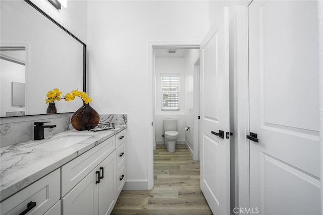3242 Harmona Pl, Los Alamitos, CA 90720 - bathroom with vanity, baseboards, wood finished floors, and toilet