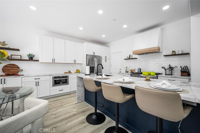 3242 Harmona Pl, Los Alamitos, CA 90720 - kitchen with tasteful backsplash, open shelves, light stone countertops, premium range hood, and stainless steel appliances