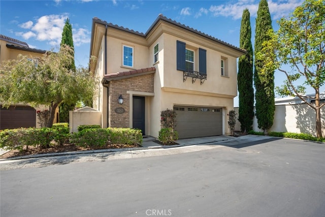 3242 Harmona Pl, Los Alamitos, CA 90720 - mediterranean / spanish-style house featuring a tiled roof, driveway, brick siding, an attached garage, and stucco siding