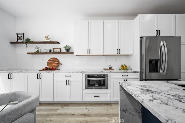 3242 Harmona Pl, Los Alamitos, CA 90720 - kitchen featuring light stone countertops, stainless steel appliances, light wood-type flooring, and white cabinetry