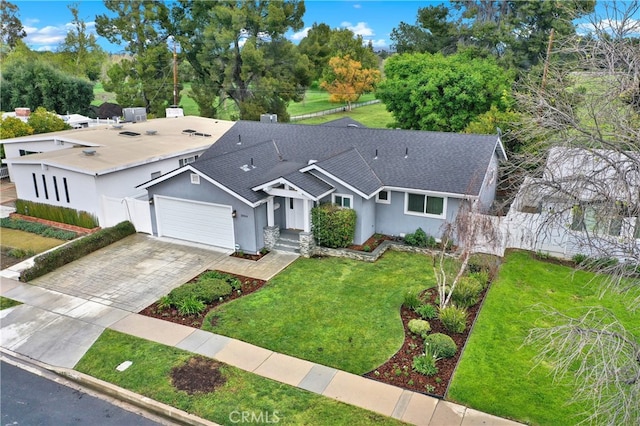 view of front facade with a front yard, fence, an attached garage, stucco siding, and decorative driveway