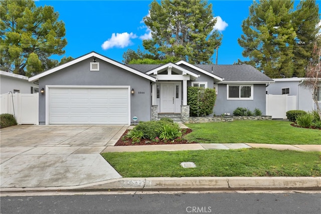 ranch-style house featuring stucco siding, a front yard, an attached garage, and fence