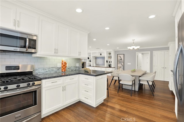 kitchen featuring dark wood-style floors, a peninsula, stainless steel appliances, white cabinets, and crown molding