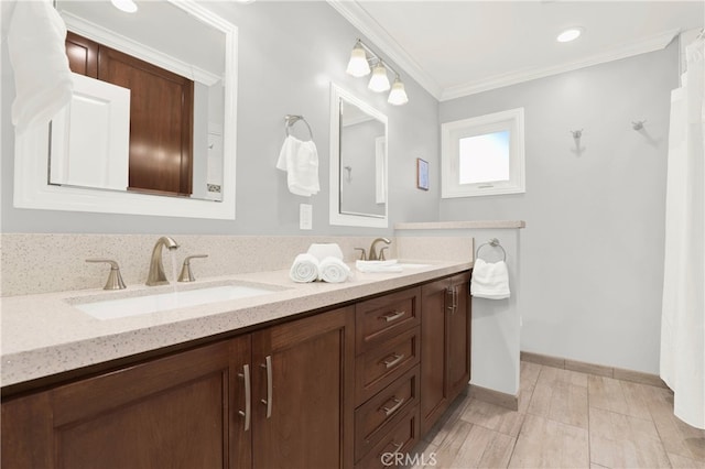 bathroom featuring a sink, baseboards, double vanity, and crown molding