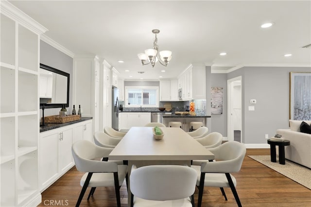 dining area featuring recessed lighting, an inviting chandelier, dark wood finished floors, and ornamental molding