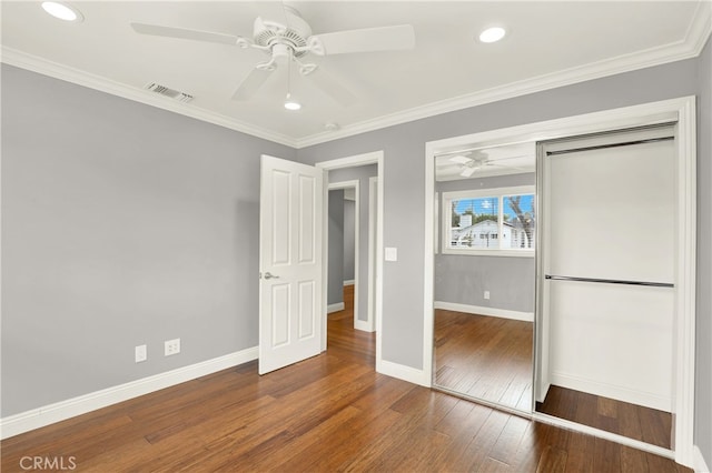 unfurnished bedroom with visible vents, crown molding, baseboards, and hardwood / wood-style flooring