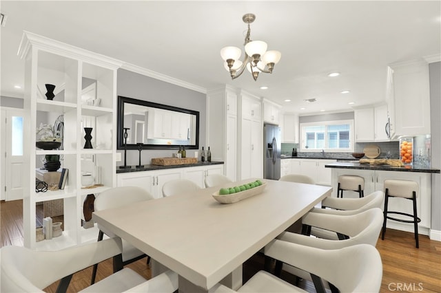 dining room featuring recessed lighting, an inviting chandelier, wood finished floors, and ornamental molding