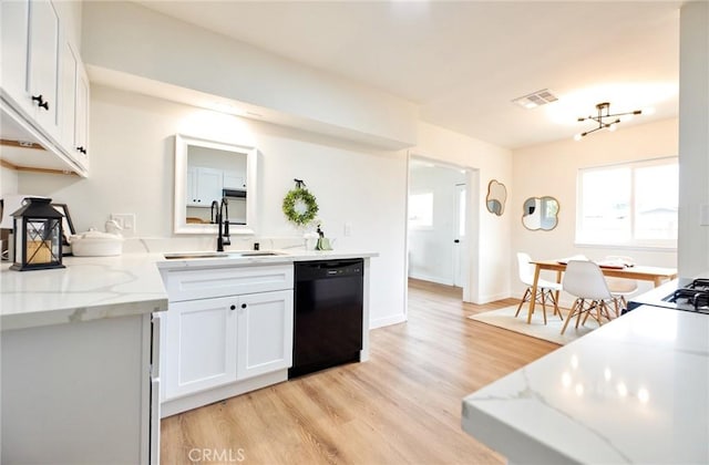 kitchen with visible vents, light wood-style flooring, a sink, black dishwasher, and white cabinets