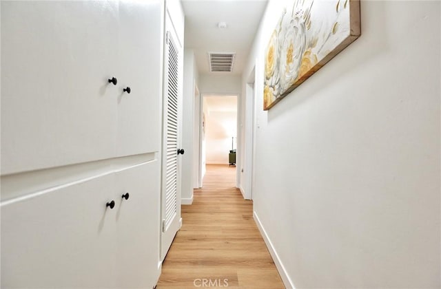 corridor featuring visible vents, light wood-type flooring, and baseboards