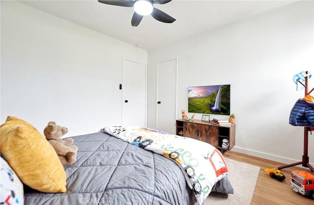 bedroom with ceiling fan, baseboards, and wood finished floors