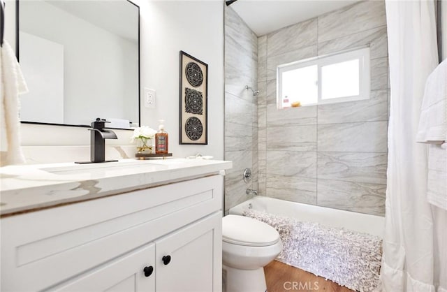 bathroom with vanity, toilet, wood finished floors, and shower / bath combo with shower curtain