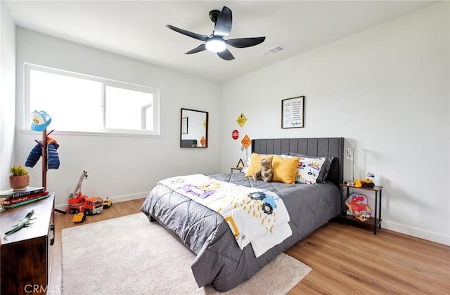 bedroom featuring wood finished floors, visible vents, and baseboards